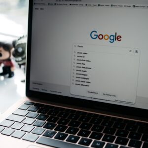 A close-up shot of a laptop displaying a Google search page with related searches visible.